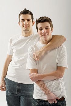 two men standing next to each other with their arms around one another and smiling at the camera