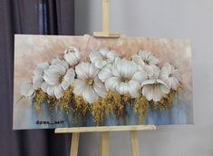 an easel with a painting of white flowers on it