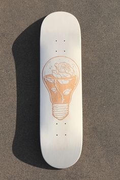 a white skateboard with an orange light bulb on it