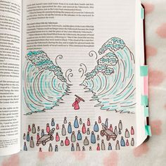 an open book with drawings on it and water in the middle, sitting on top of a bed