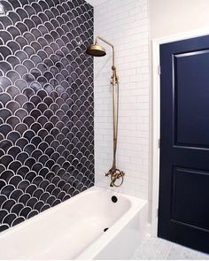 a white bath tub sitting under a faucet next to a blue door in a bathroom