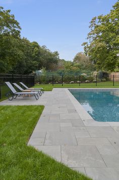 an empty swimming pool surrounded by lush green grass