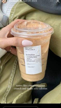 a person holding a cup of coffee with a price label on the top and bottom