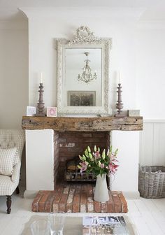 a living room filled with furniture and a fire place in front of a mirror on the wall