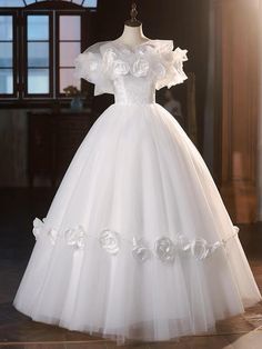 a white wedding dress with flowers on the skirt