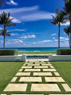 an outdoor area with grass and plants near the ocean