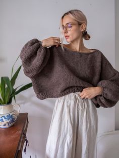 "Stylish chunky crop sweater with long balloon sleeves and boat neckline. Can be made to order in any color from the color card. Materials: wool blend (wool/acrylic) Color of the modeled sweater: brown melange - made in size S/M (see the measurements) Measurements of size S/M: Length: front 18\" = 46 cm back 20\" = 50 cm Chest: 32\" = 81 cm Measurements of size L/XL Length: front 20\" = 50 cm back 22\" = 55 cm Chest: 34\" = 86 cm Measures of Model in the photo Size: S Chest: 32\" - 82 cm Waist: Knit Chunky Sweater, Oversized Cropped Sweater, Chunky Knit Jumper, Pullover Outfit, Cropped Pullover, Oversized Pullover, Pullover Sweater Women, Boat Neckline