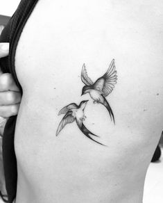 a black and white photo of a bird on the back of a woman's stomach