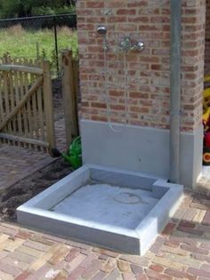 an outdoor shower in the middle of a brick patio