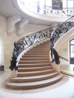 a spiral staircase with wrought iron railing in a building