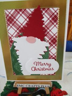 a christmas card with an image of a santa clause on the front, and a wooden sleigh in the back