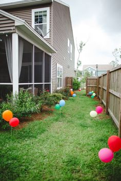 some balloons are in the grass near a house