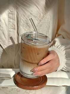 a woman holding a cup with a straw in it