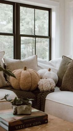 a living room filled with lots of furniture and pillows on top of a wooden table