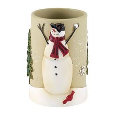 a ceramic snowman is sitting in the middle of a cup with trees on it