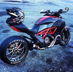 a red and black motorcycle parked in a parking lot