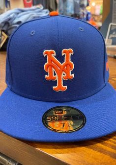 a new york mets hat sitting on top of a wooden table