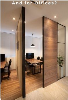 an office with wooden floors and glass partitions to divide the room from the dining area