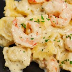 pasta with shrimp and cream sauce on a black plate