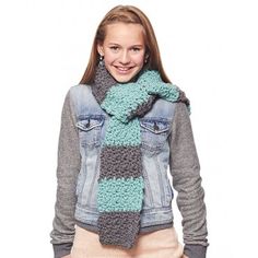 a young woman wearing a jean jacket and a knitted scarf in shades of blue, grey and green