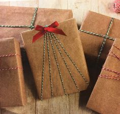 three wrapped presents with red ribbon and twine