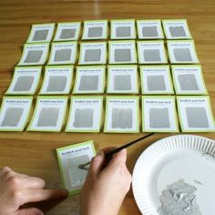 a person is cutting out some cards with scissors