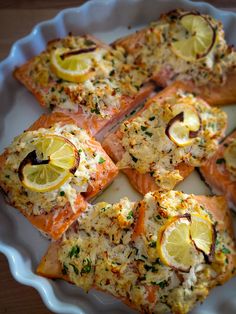 salmon with lemons and herbs on a white plate