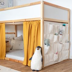 a penguin is standing in front of a bunk bed with curtains on the bottom and side