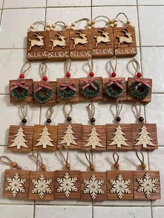 christmas ornaments are hanging on the wall in front of a tile floor with words above them