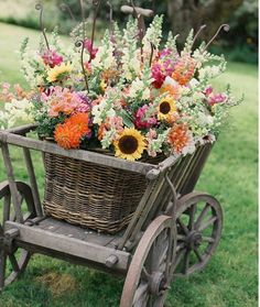 a basket filled with flowers sitting on top of a wooden cart