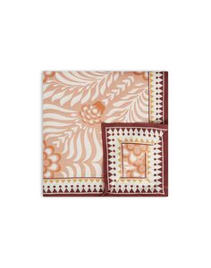 two placemats with an orange and white design on the top one has a red border