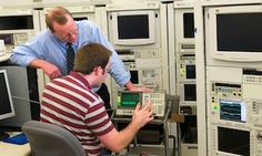 two men working in an electronics control room