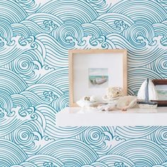 a shelf with some seashells on top of it and a blue wallpaper