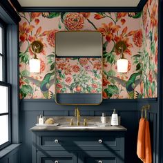 a bathroom with blue walls and floral wallpaper on the vanity, along with a gold framed mirror