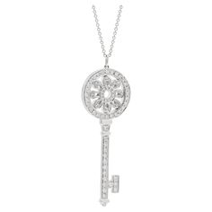 TIFFANY & CO, A DIAMOND PETALS KEY PENDANT NECKLACE Tiffany Keys are radiant symbols of a bright future. This dazzling pendant glows with diamonds, illuminating the face. Brilliant beacons of optimism and hope, Tiffany Keys are radiant symbols of a bright future. This dazzling pendant glows with diamonds, illuminating the face. 18ct white gold, designed as a key with a flower motif, set throughout with round brilliant cut diamonds 1.18 carats of diamonds Signed Tiffany & Co Stamped Au750, Pendan Tiffany White, Tiffany Key, Gold Tiffany, Key Pendant Necklace, Flower Motif, Key Pendant, Bright Future, Round Brilliant Cut Diamond, Tiffany & Co.