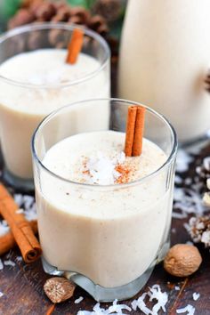 two glasses filled with milk and cinnamon sticks