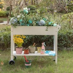 an outdoor potting bench with flowers and gardening tools