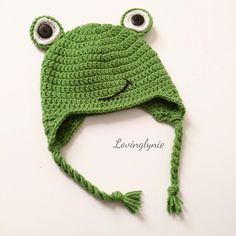 a crocheted frog hat with eyes on it