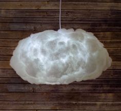 a white cloud hanging from a string on a wooden wall