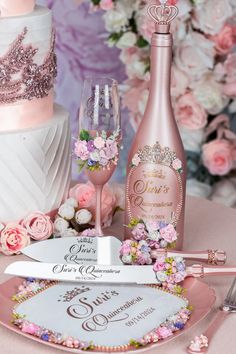 a table topped with pink flowers next to a cake