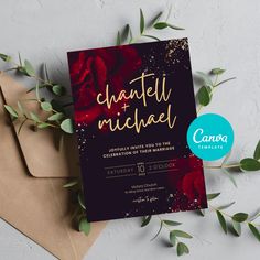 an elegant wedding card with red roses and gold foil lettering on it, next to some envelopes