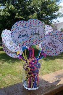 a vase filled with lots of balloons and streamers