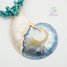 The White Nautilus shell is from Netherland and crafted in Indonesia. The Necklace is made of small Light blue Racine beads string together each bead to be a beading line and twist each line to be one line to stronger and look beautiful, and it is 18 inches long, weight 45g. (including pendant)   It's a real seashell from farming which it's fed by the seaweed, not from the natural environment due to environmental conservation. Our product was crafted with craftsmanship from one generation to one generation, and it may not last forever. Unlike a product that is made by machine. It's not just an ordinary necklace but it's about the taste of the wearer. It's for you or anyone who infatuates nature which each of the shells may look alike but not the same in color and texture. It's very UNIQUE. Blue Beaded Shell Necklace Ocean-inspired, Ocean-inspired Blue Beaded Shell Necklace, Blue Shell Jewelry With Colorful Beads, Turquoise Shell Beaded Necklaces With Round Beads, Turquoise Shell Beaded Necklaces, Ocean-inspired Beaded Shell With Round Beads, Ocean-inspired Blue Shell Beaded Necklaces, Blue Shell Necklace With Colorful Beads For Gift, Handmade Adjustable Blue Shell