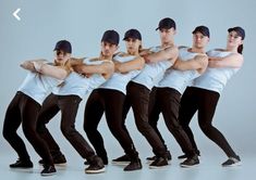 a group of young men standing next to each other in front of a white background