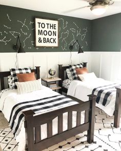 two twin beds with black and white bedding in a room that has stars on the wall