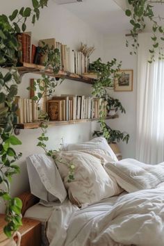 an unmade bed with white sheets, pillows and plants on the shelves above it