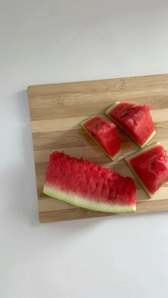 four slices of watermelon on a cutting board