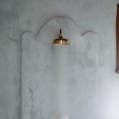 a bathroom with a gold faucet and marble walls