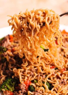 a spoon full of noodles with meat and vegetables