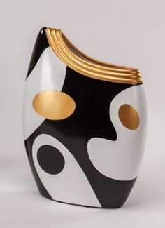 a black and white vase with gold accents